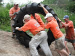The staff hauling a giant tire straight up the bank